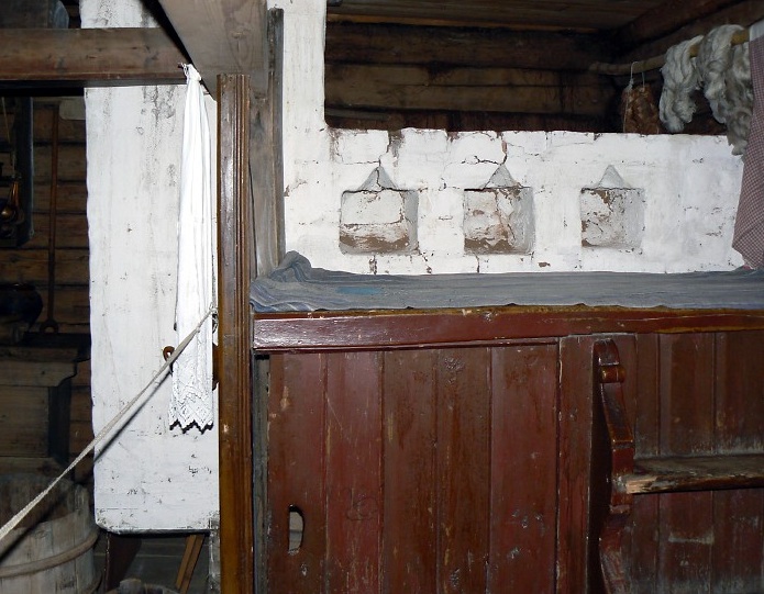 Kostroma, Museum of Wooden Architecture, home of a poor peasant - stove with sleeping area above and cupboard for sickly calves