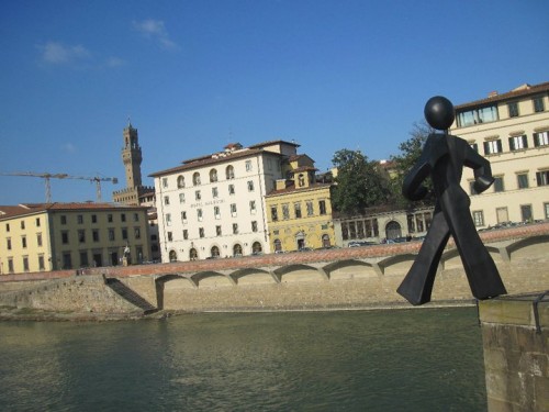 Clet's Common Man taking a step off the Alle Grazie Bridge